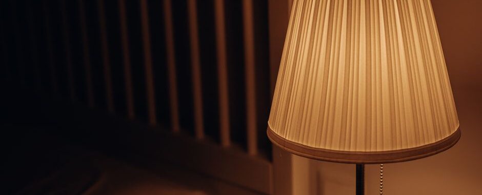 Stijlvolle hanglamp boven een bed in een gezellige slaapkamer met warme kleuren en een moderne inrichting.